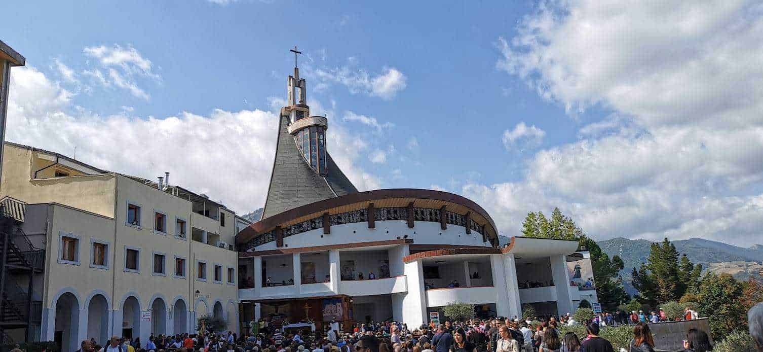 Tempio di San Giovanni Bosco a Castel Giffredo, chiesa moderna con architettura innovativa, frequentata da molti fedeli e visitatori, in una località con paesaggi montani e cielo sereno.