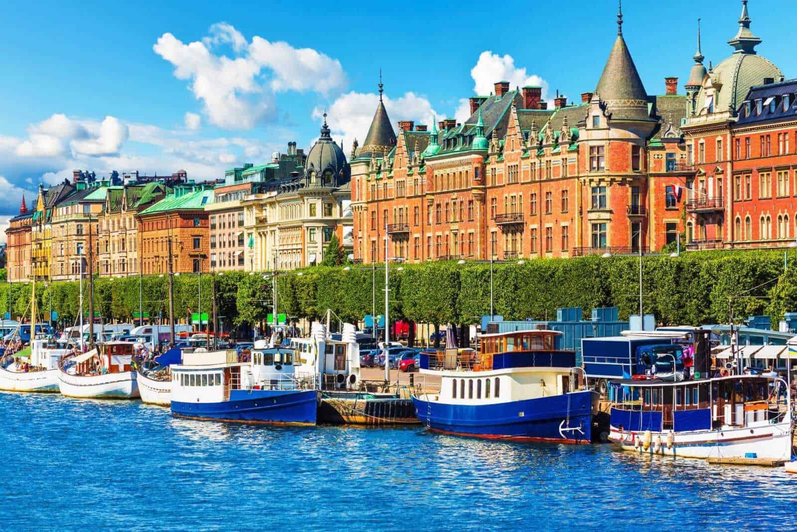13 Città con canali nel mondo da vedere 8 Barche nel porto di Stoccolma con edifici storici sullo sfondo, vista sul mare svedese, immagine di un porto turistico svedese, architettura urbana di Stoccolma, città nordica e turismo marittimo.