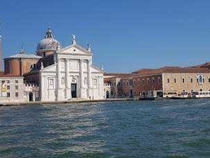 Venezia, Basilica di Santa Maria della Salute vista dal canal Grande, con il cielo sereno e le acque tranquille della laguna veneta.