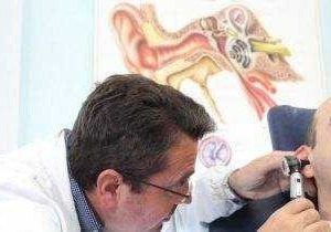 Titolare di uno studio medico che effettua un esame audiologico per la diagnosi di problemi uditivi.