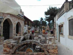 Antica fontana in pietra nel centro storico di un borgo italiano, con case tradizionali e atmosfera rurale. Perfetta per foto di paesaggi autentici e cultura locale.