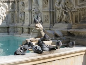 Fontana con statue di leoni e figure scolpite in marmo, ambientata in un contesto storico, con acqua che scorre nella vasca. Perfetta per immagini di monumenti storici e arte classica.