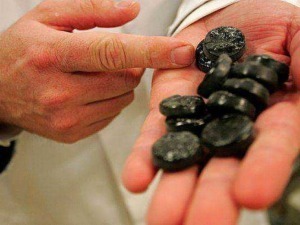 L'alt text: Pezzo di carbone dolce tradizionale in mano, perfetto per dolci natalizi e simbolo di buon auspicio in Italia.