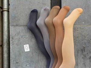 Calze colorate in vari toni su pavimentazione urbana, perfette per completare look casual e alla moda. La varietà di colori include nero, grigio, marrone, beige e giallo, ideali per ogni stile.