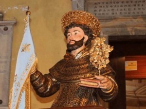 Statua religiosa di San Francesco d'Assisi in abito tradizionale, con palletta e croce, simbolo di spiritualità e devozione.