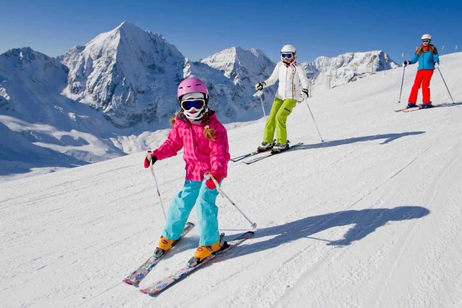 Neve e sport in montagna con bambini che sciano sulle, paesaggi innevati, attività invernali per famiglie