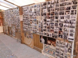 Foto di un muro decorato con tante foto storiche e ricordi, parte di un’esposizione di foto antiche e recenti, probabilmente di eventi, persone e momenti significativi.