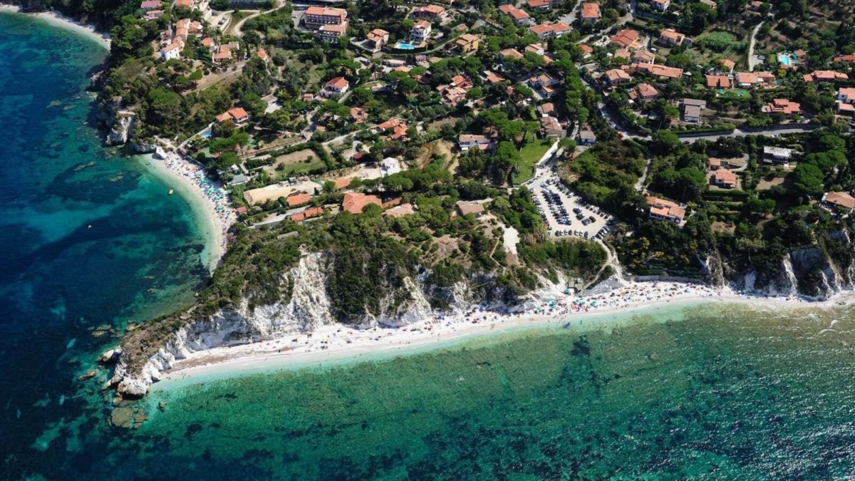 Spiaggia romantica con scogliere e acque cristalline sulla costa italiana.