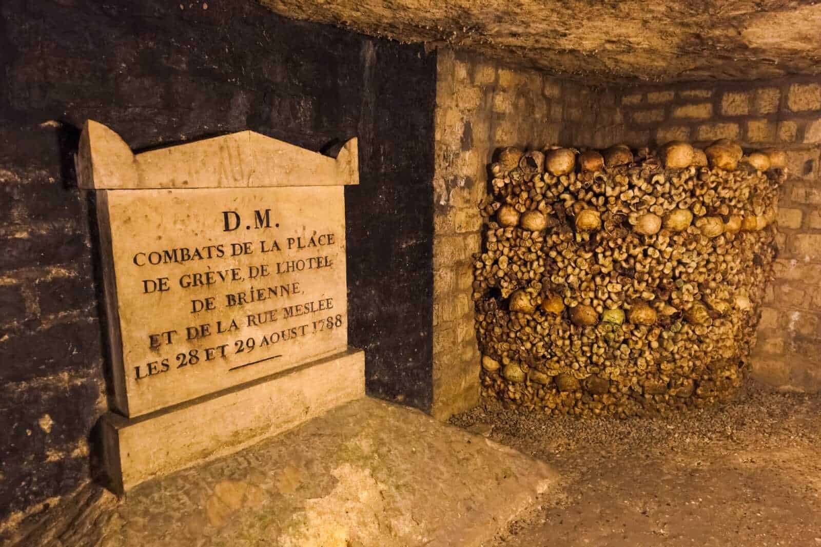 Veduta suggestiva dei corridoi delle Catacombe di Parigi con pareti di ossa e teschi ordinati lungo il percorso sotterraneo.