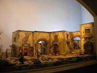 Antica rovina storica illuminata di sera con resti archeologici e strutture in pietra, in un ambiente storico e culturale suggestivo.