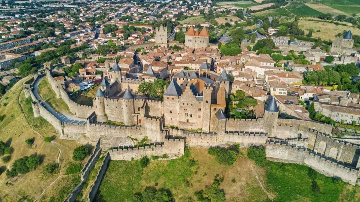 Castello medievale e centro storico di una città France, viste aeree con mura antiche e torri, paesaggi rurali e ingegneria storica, destinazioni turistiche culturali e itinerari di viaggio.
