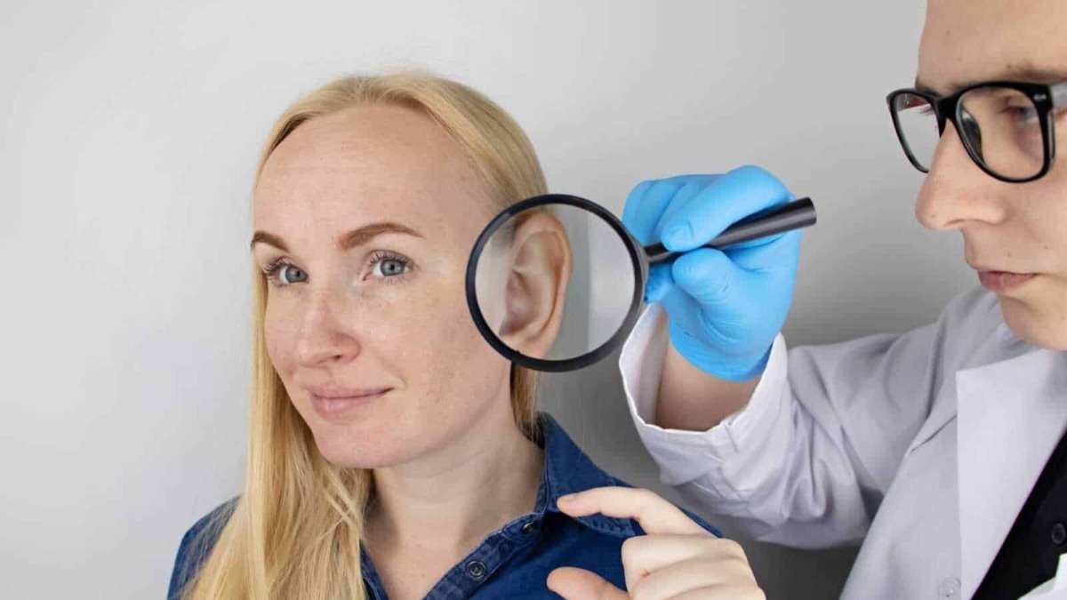 Diagnosi dell'orecchio con un medico otorinolaringoiatra usando una lente d'ingrandimento. Visita specialistica, controllo udito e monitoraggio della salute auricolare.