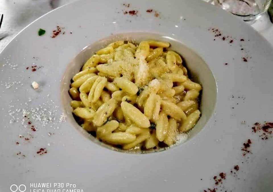 Crema di pasta fresca con formaggio e spezie, piatto tipico italiano servito in un ristorante elegante, perfetto per gli amanti della cucina tradizionale e gourmet.