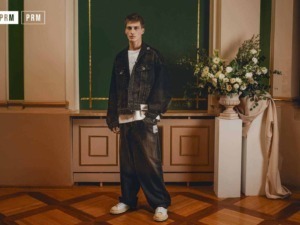 Vestito jeans maschile, stile streetwear, look casual, moda uomo, outfit denim nero, giovane uomo moda, pantaloni larghi, sneakers bianche, scena elegante, ambiente raffinato.