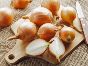 Aglio fresco e schiacciato su tagliere di legno con coltello, saporito ingrediente per cucina tradizionale italiana, ideale per condimenti e ricette casalinghe.