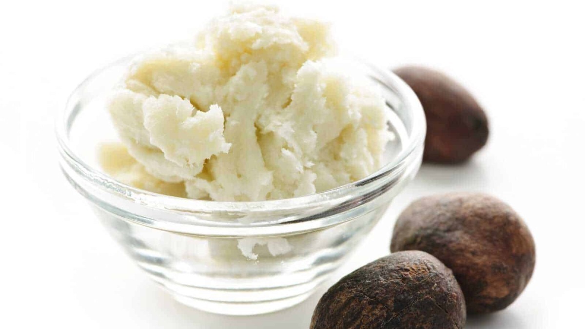 Crema di nocciole fatta in casa in ciotola di vetro con nocciole crude per dolci e colazione, preparazione di whipped hazelnut spread, ingredienti naturali italiani.