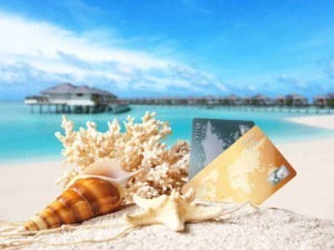 Carte di credito sulla spiaggia con conchiglie e corallo, paradiso tropicale, vacanze al mare, overwater bungalows, resort di lusso, estate, relax, destinazioni esclusive, viaggio.