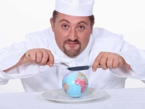 Terra in miniatura con coltello, simbolo del gastronomia mondiale, in scena con chef professionista che sembra tagliare il pianeta per evidenziare l'uso di ingredienti globali.