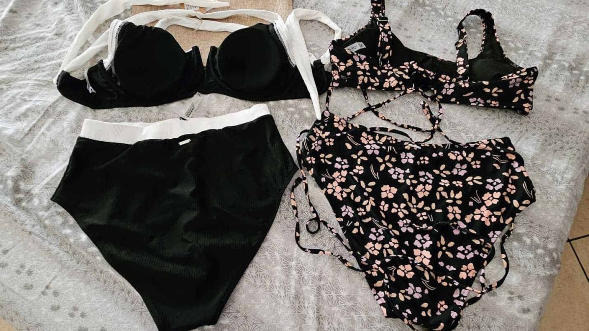 Lingerie elegantemente disposta su un letto con lenzuola chiare, includendo un reggiseno nero con pizzo.