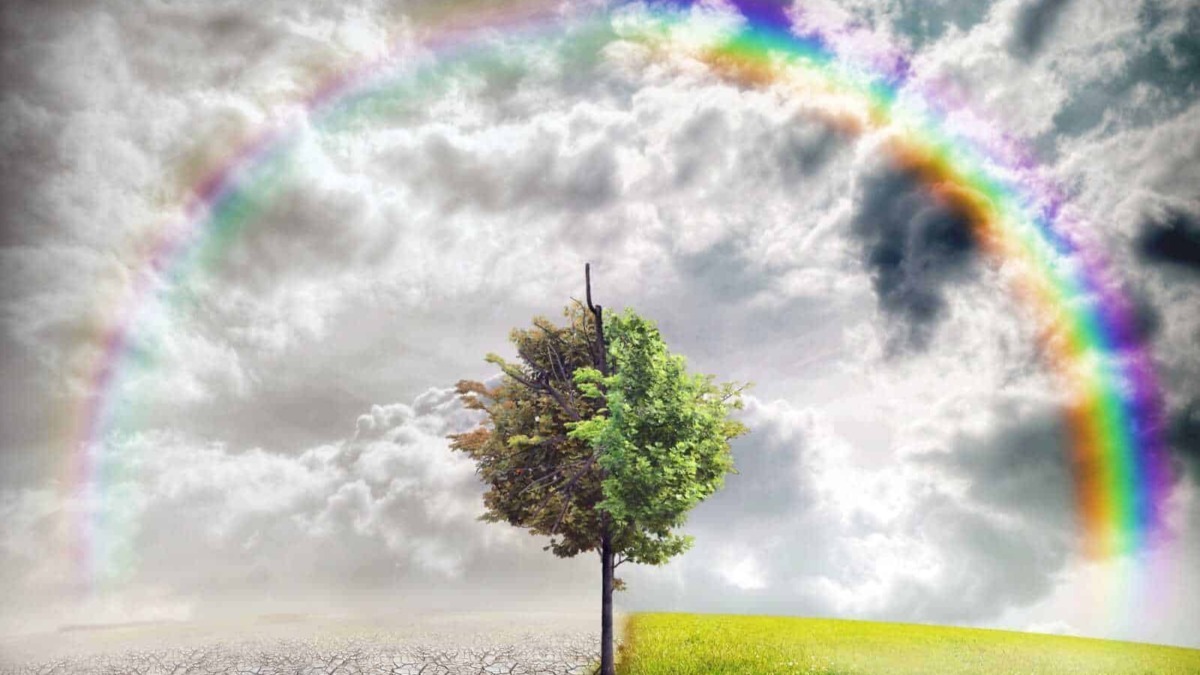 Arcobaleno tra cieli tempestosi e terreni aridi, simbolo di speranza, rinascita e equilibrio tra natura e cambiamenti climatici.