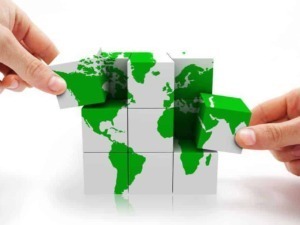 Mondo su cubi puzzle con mappe verdi e bianche, rappresentazione globale e geografia, simbolo di connessione internazionale e collaborazione.
