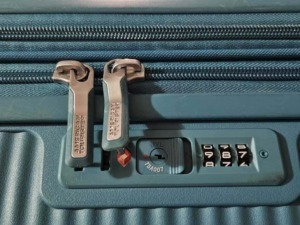 L'asta di chiusura di una valigia rigida con combinazione di sicurezza 3 cifre, progettata per proteggere i contenuti durante i viaggi.