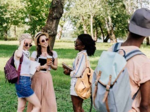 Giovani donne che esplorano un parco durante una gita, scambiando conversazioni e condividendo momenti di amicizia all'aperto.