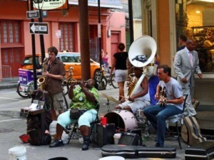Accordi musicali di street band jazz con musicisti che suonano strumenti come sax, tromba, tuba e chitarra in un contesto urbano vivace e dinamico.