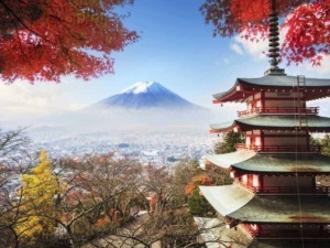 Vista panoramica di Monte Fuji con tempio tradizionale giapponese e foliage autunnale colorato.