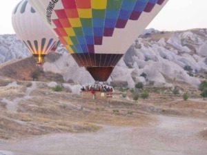 Colorato pallone aerostatico con passeggeri in panoramica sul paesaggio naturale di Cappadocia, Turchia.