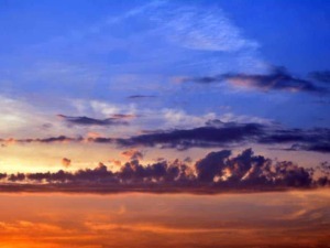 Splendido tramonto con nubi colorate, cielo blu e sfumature calde di arancione e viola, perfetto per apprezzare la bellezza naturale del cielo al crepuscolo.