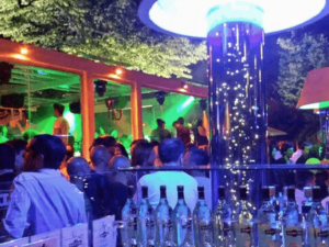 Gruppo di persone che si divertono in un club notturno con luci colorate e atmosfera vivace, ambiente moderno e alla moda, perfetto per serate di svago e socializzazione.