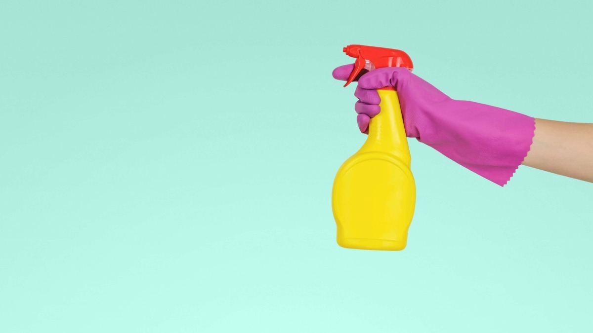 Spruzzatore di sapone giallo con guanto rosa, immagine di pulizia e igiene, detergente, ambiente di casa, pulizia e cura della casa.