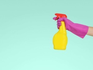 Spruzzatore di sapone giallo con guanto rosa, immagine di pulizia e igiene, detergente, ambiente di casa, pulizia e cura della casa.