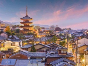 Pagoda giapponese con case tradizionali e cielo al tramonto, scenografia di un villaggio giapponese, atmosfera serale nel quartiere storico.