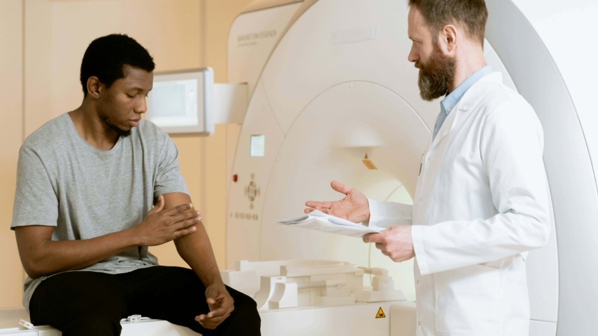 Imaging scans, consulente medico e paziente in ambulatorio. Qualità delle immagini sanitarie e diagnosi. Immagine di un medico e un giovane paziente durante una visita medica in clinica radiologica.