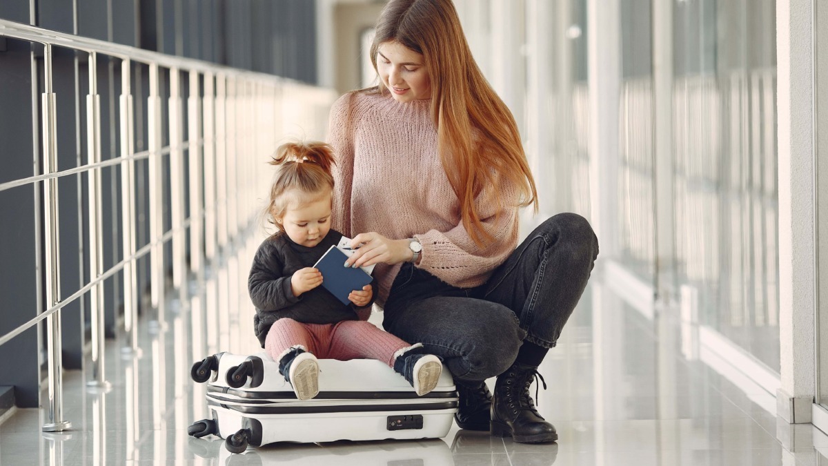 Bagaglio da viaggio con madre e bambina in aeroporto, concetto di famiglia, viaggio e relax.