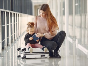 Bagaglio da viaggio con madre e bambina in aeroporto, concetto di famiglia, viaggio e relax.