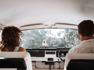 Automobile vintage con coppia in viaggio attraverso paesaggi naturali alberati, atmosfera retro, viaggio in auto, esplorazione, avventura, viaggio in coppia, auto d'epoca, natura, relax, libertà.