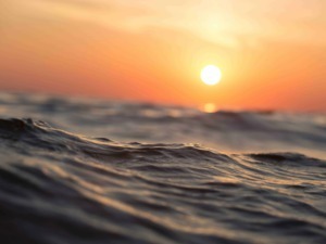 Onde del mare al tramonto, vista ravvicinata, atmosfera serena e colori caldi, scena naturale e rilassante.