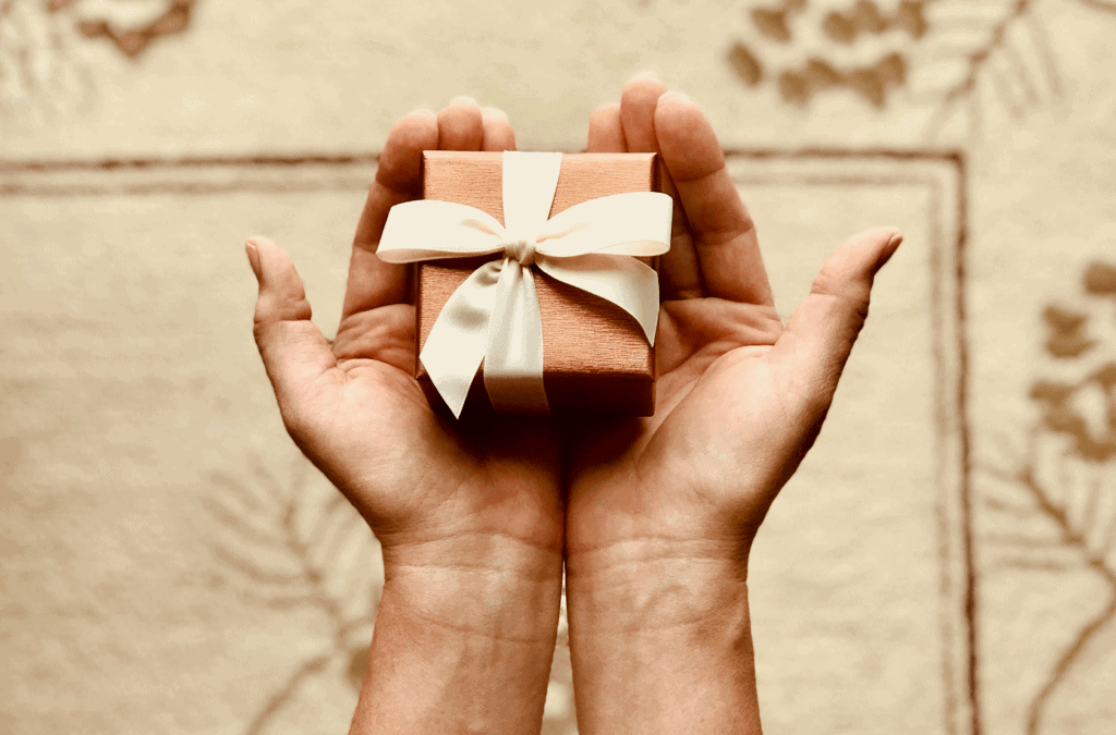 Piccolo regalo con fiocco in mano, idea di regalo speciale, presentazione di un dono per occasioni come compleanni o anniversari, simbolo di affetto e pensiero gentile.