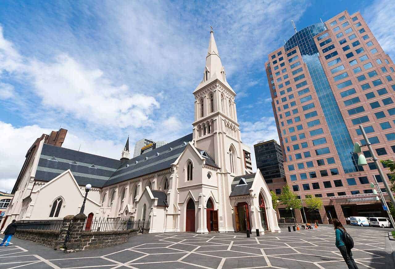 Cos'è il gotico, arte gotica dal classico al moderno 3 Immagine di una chiesa storica circondata da moderni grattacieli a Auckland, Nuova Zelanda, sotto un cielo sereno. Perfetta combinazione tra architettura antica e moderna.