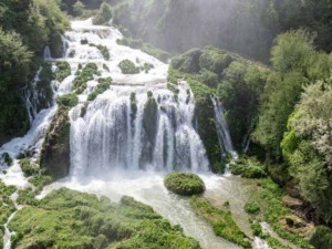 Cascata mozzafiato immersa in un paesaggio naturale di foresta verde e muschi, ideale per scoprire la bellezza della natura e itinerari di trekking in luoghi tranquilli e suggestivi.