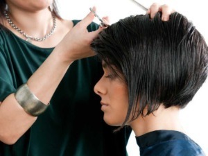 Taglio di capelli moderno e stile elegante, parrucchiere professionista che lavora su una cliente con capelli corti e lisci, trattamento di styling in salone di bellezza.
