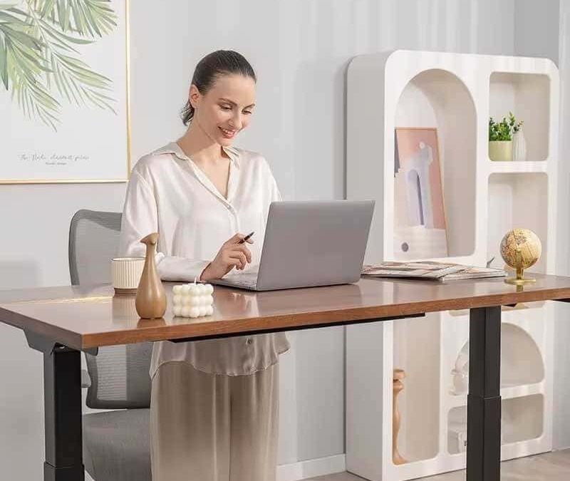 Schermata di donna sorridente mentre lavora al computer in un ambiente elegante e minimalista con decorazioni moderne e piante verde chiaro.