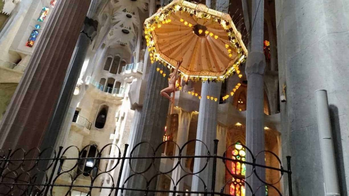 Lampadario decorativo all'interno della basilica di Sagrada Família, con illuminazione calda e dettagli artistici, simbolo di architettura innovativa e arte sacra a Barcellona.