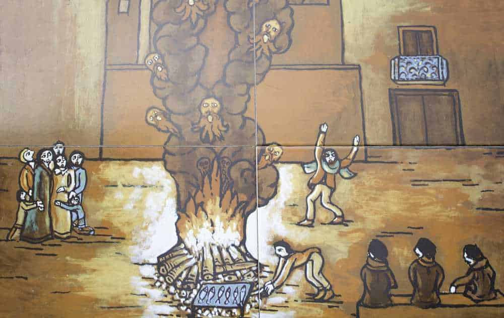 Fiamme che avvolgono un albero con figure umane e animali, mentre persone assistono e interagiscono, rappresentando una scena simbolica nella street art italiana.