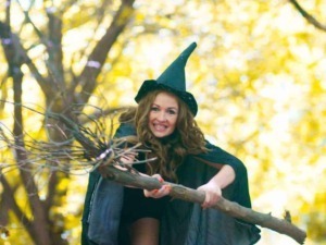 Strega con cappello a punta in un bosco autunnale, scena magica e fiabesca di Halloween e magia, ambientazione misteriosa.