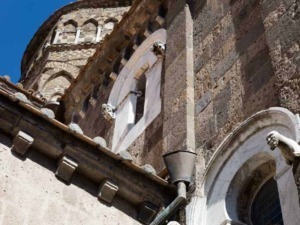 Faro sulla chiesa medievale in pietra con dettagli architettonici storici e antichi.