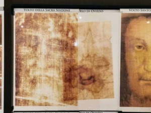 Ritratto del Volto della Sacra Sindone e del Volto Santo di Manoppello esposti su pannello informativo, illustrando l'arte religiosa e le reliquie storiche della tradizione cristiana.